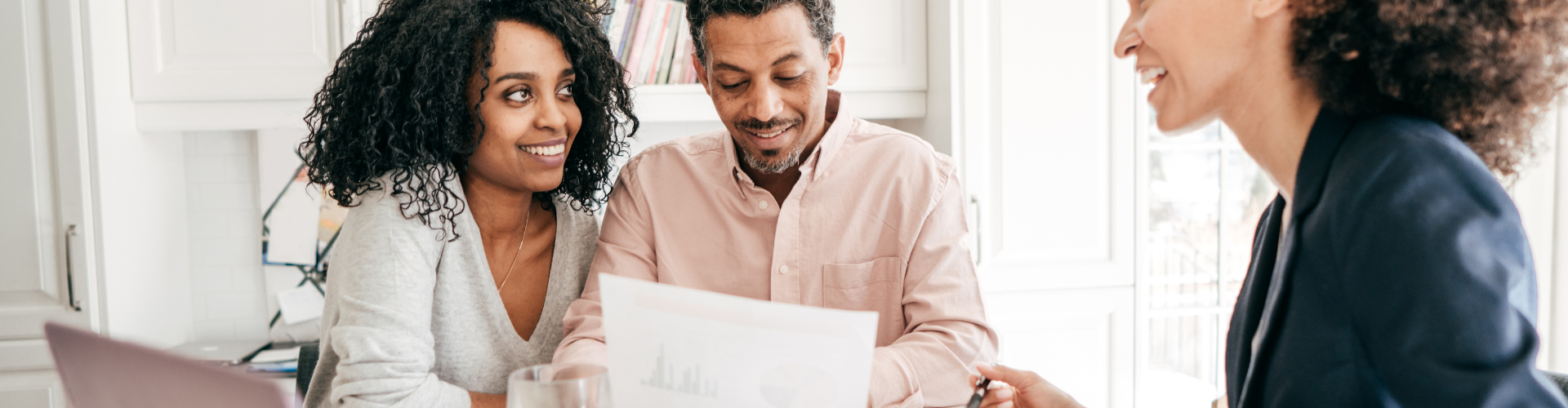 A group of people looking at a laptop.