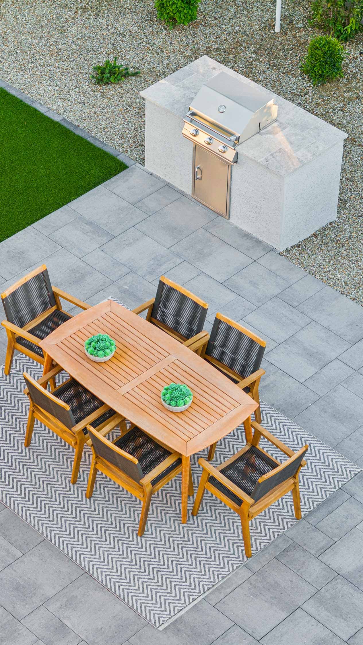 Editorial lifestyle photo detail shot of outdoor kitchen station with grill, table and chairs perfect for entertaining- new construction homes near Amarillo ranch palomino ranch in Maricopa AZ with USDA new construction