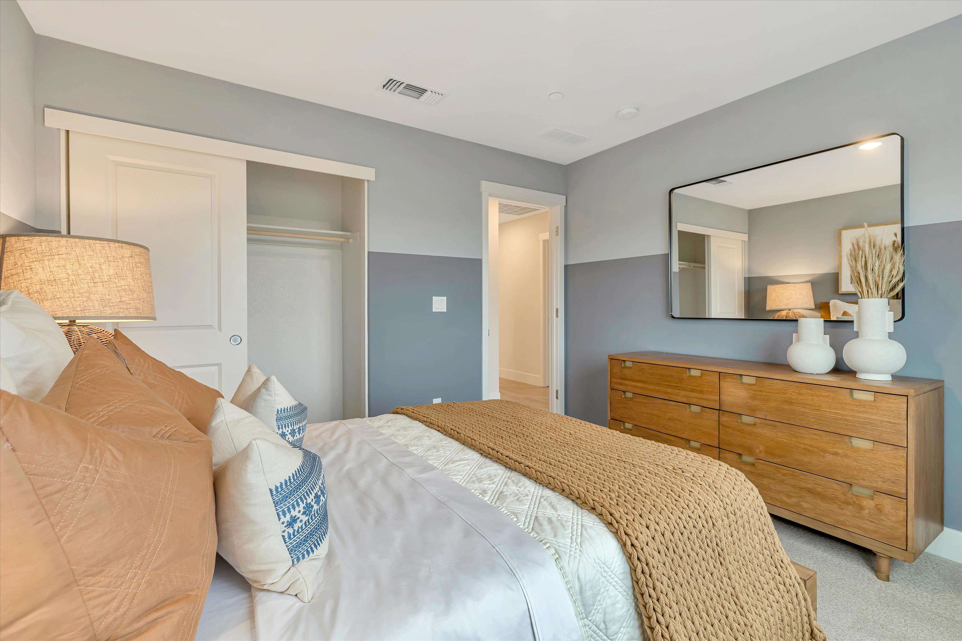 A bedroom with a bed and a dresser.