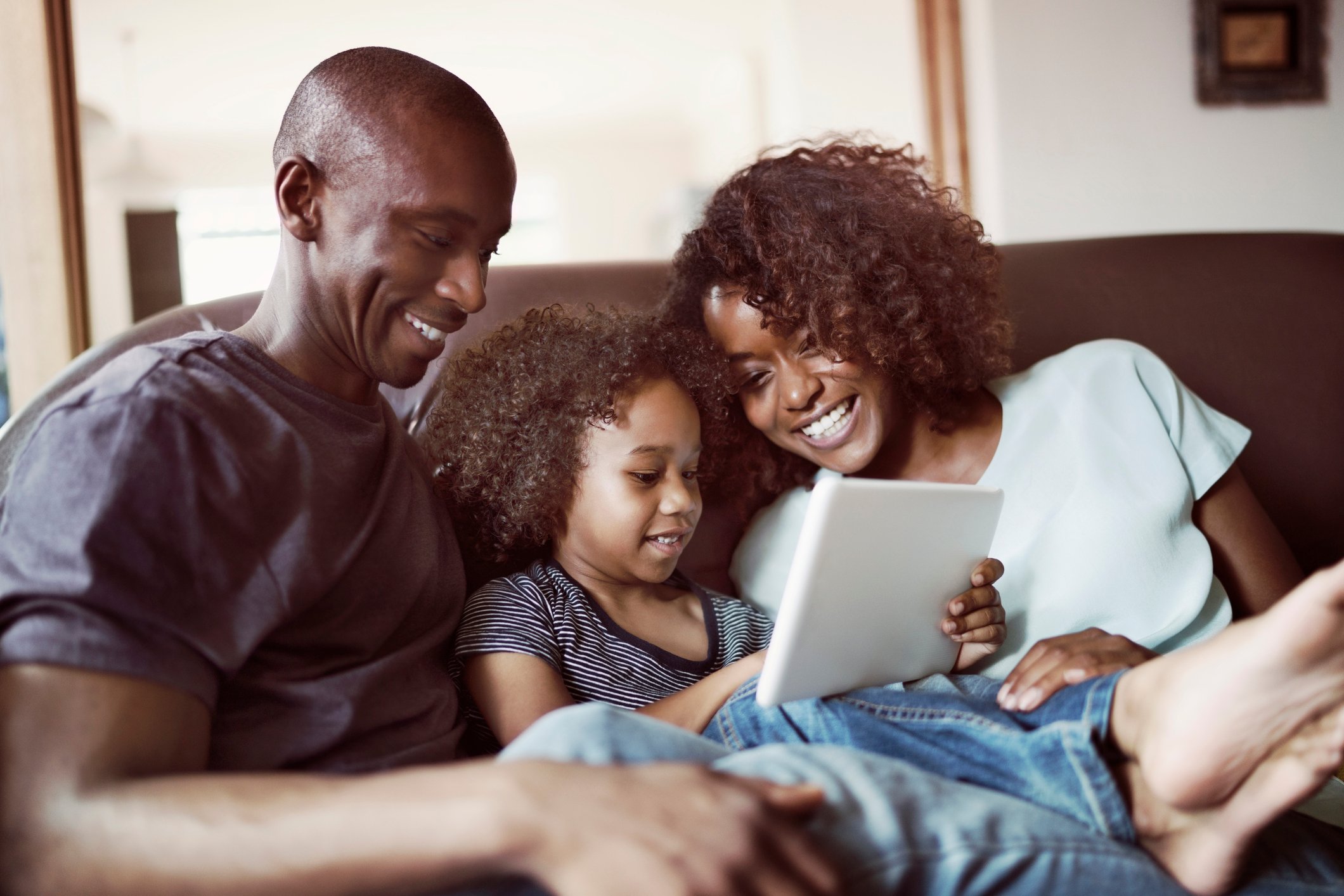 A family sitting on a couch.