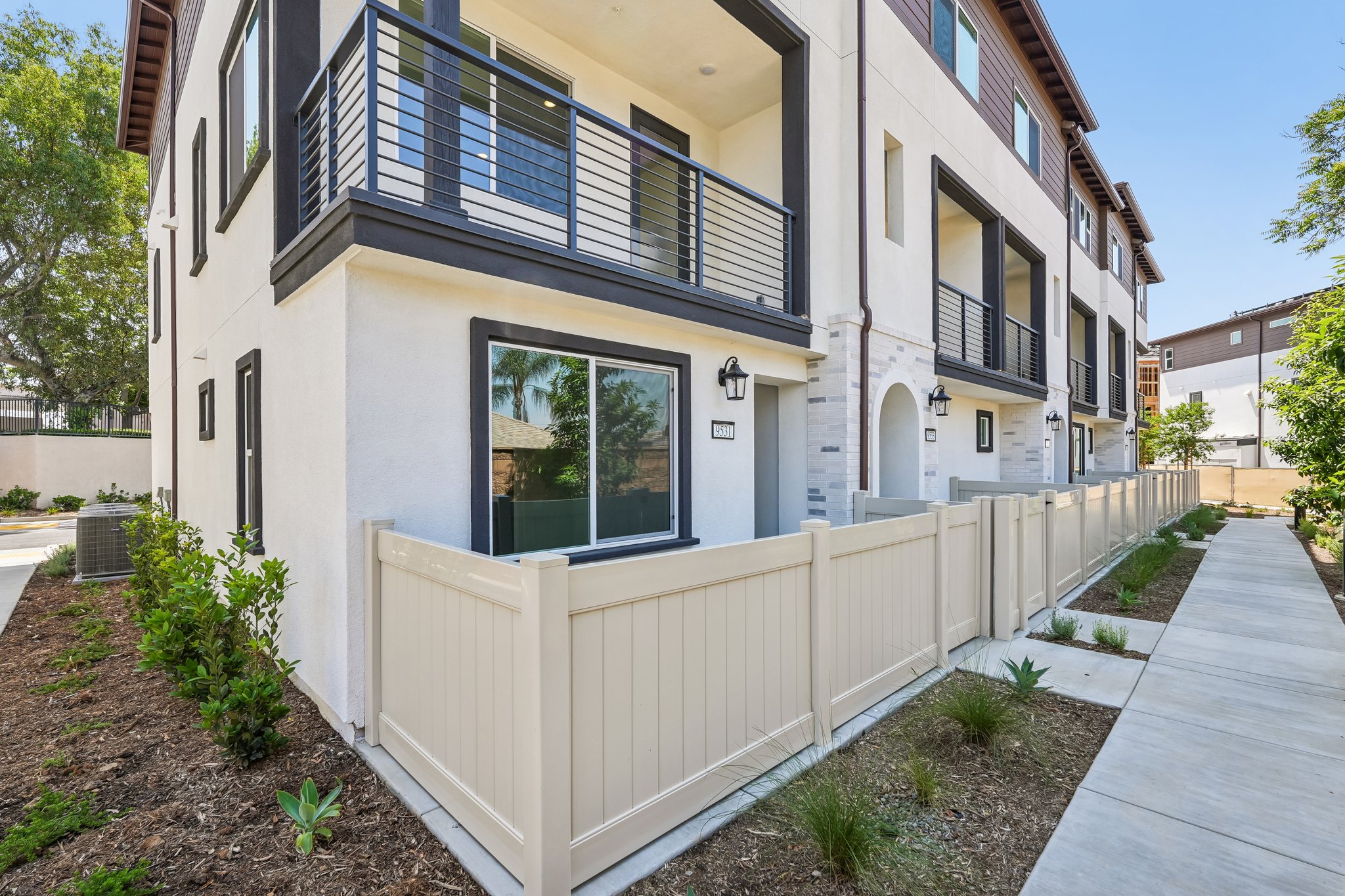 A white building with a white fence.
