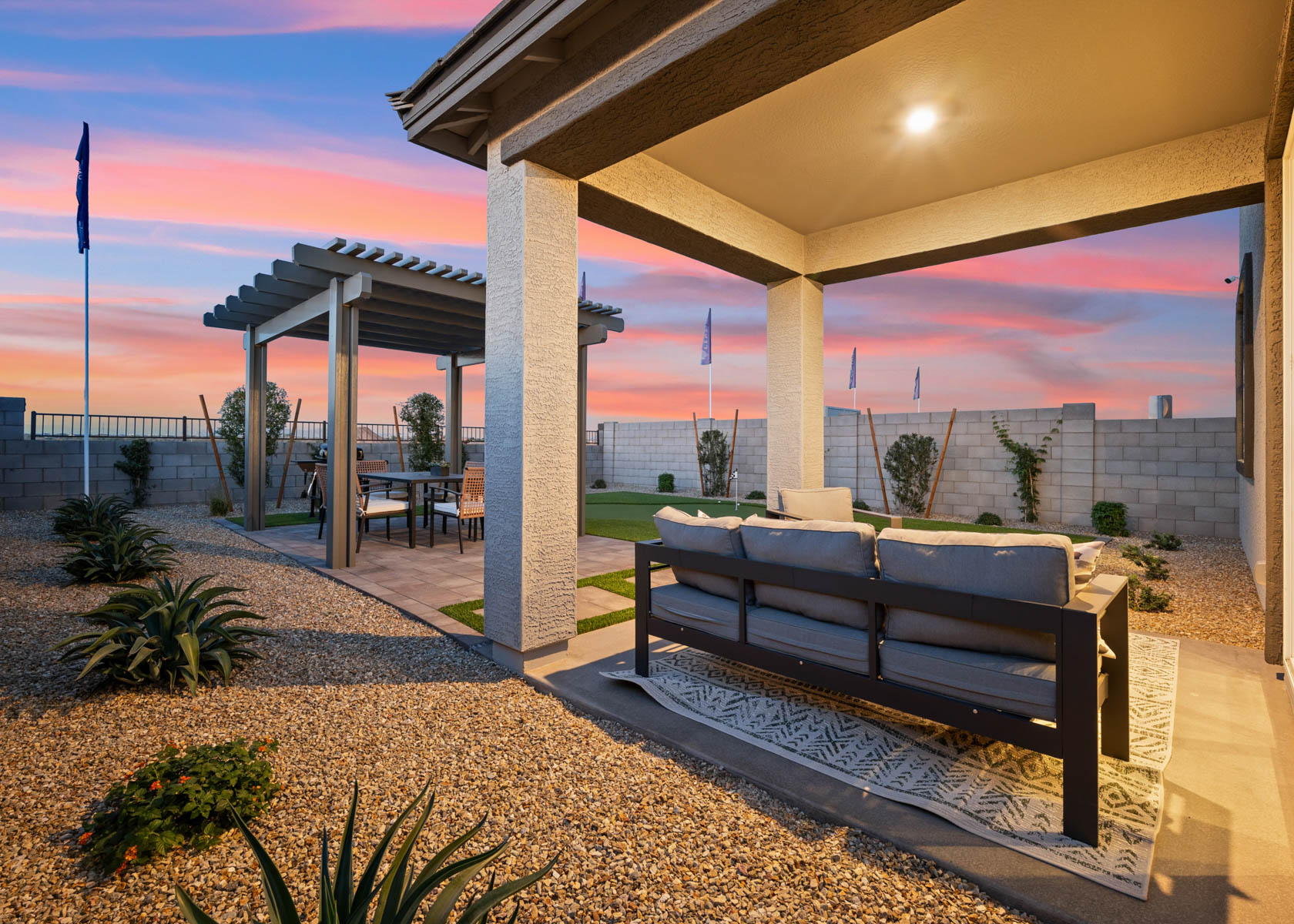A couch and a table under a covered patio.