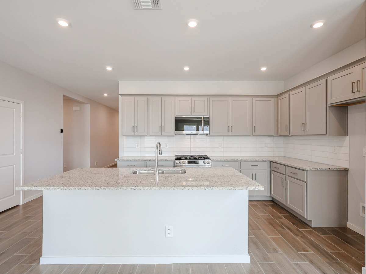 A kitchen with white cabinets.