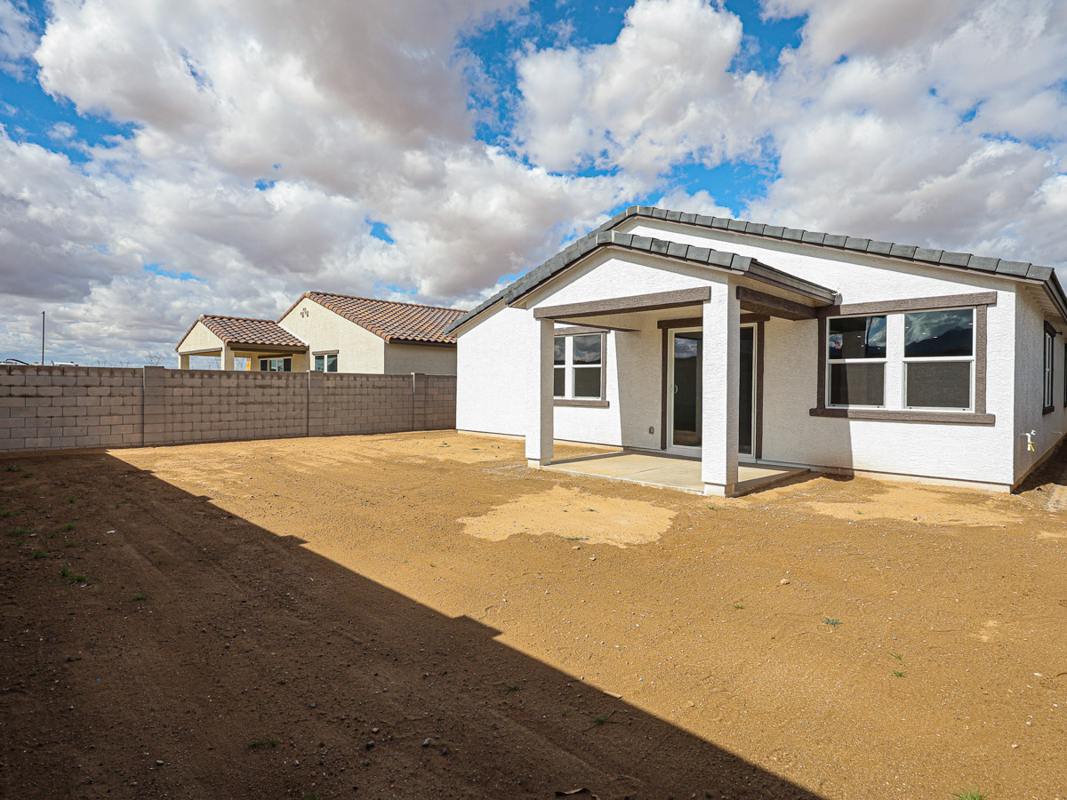 A dirt road leading to a house.
