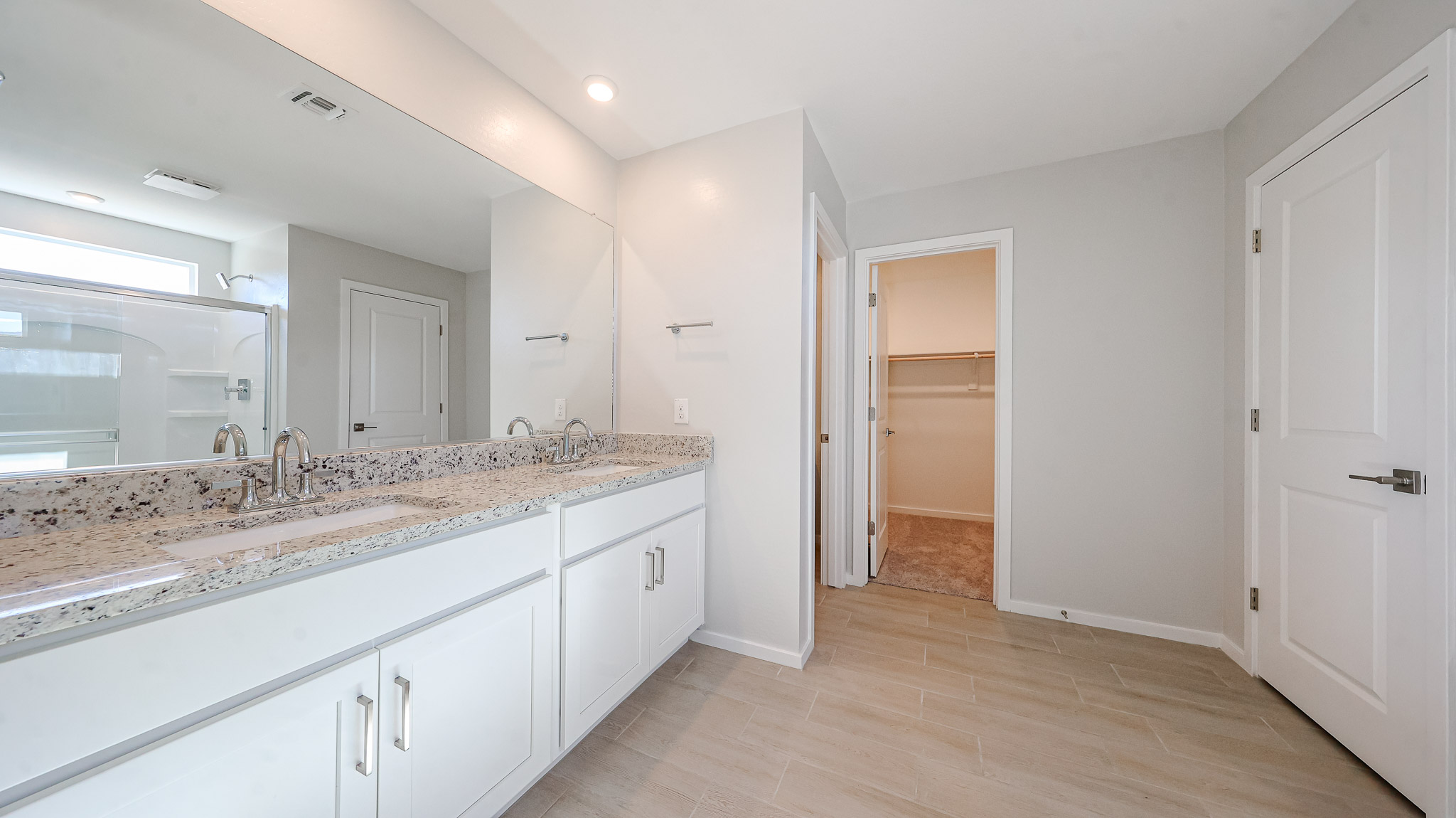 A bathroom with white cabinets.