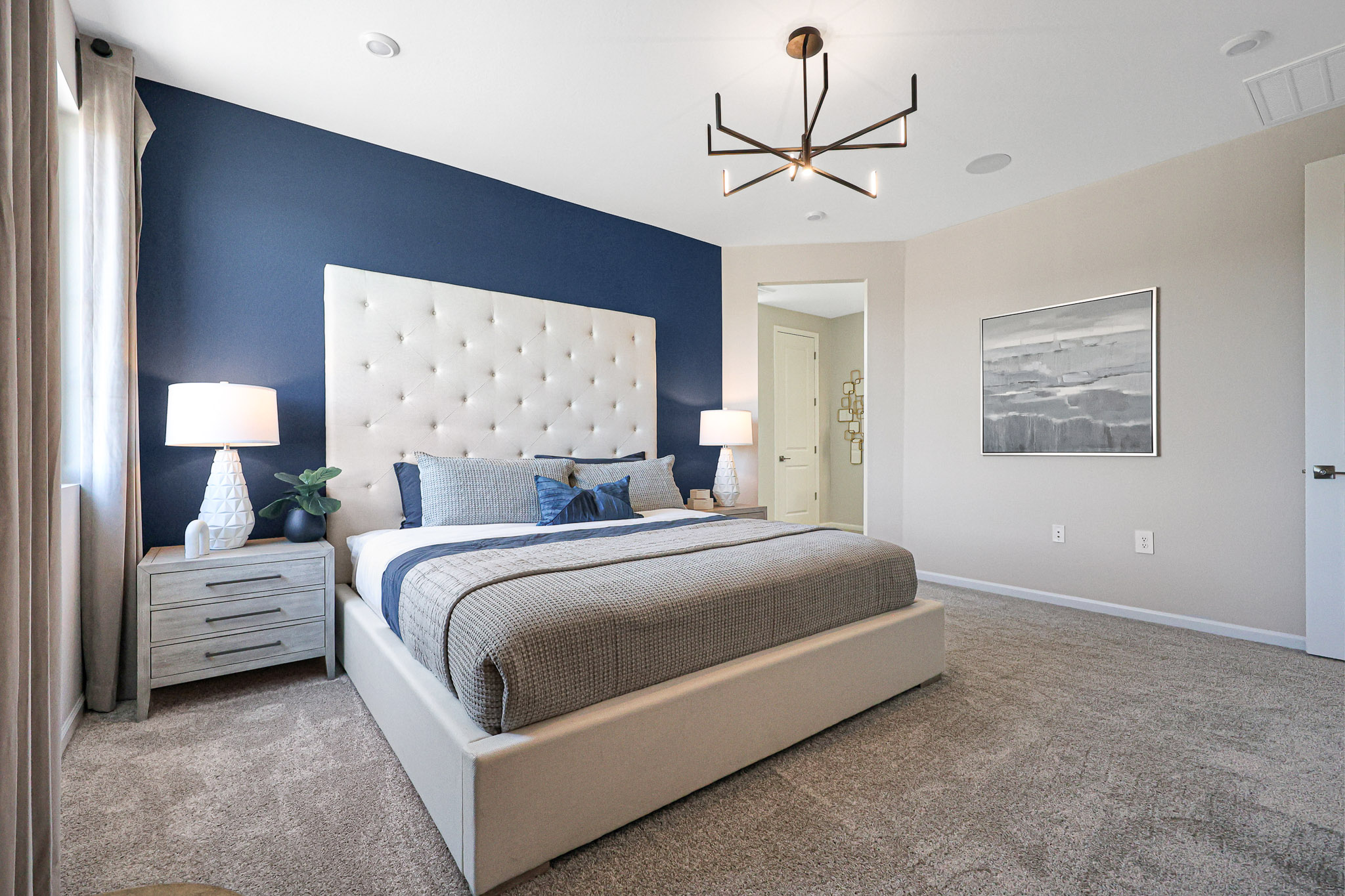 A bedroom with a bed and lamps.