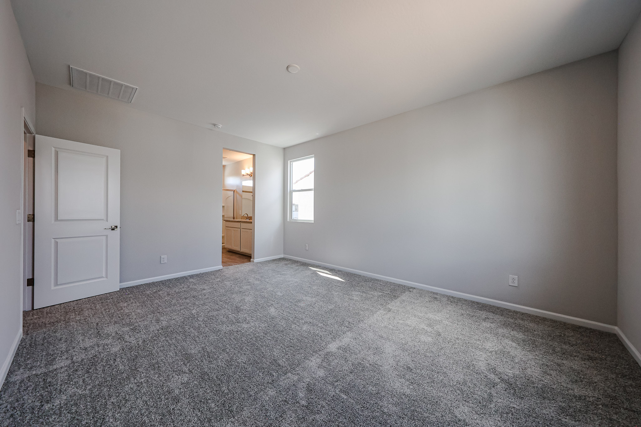 A room with a carpet and a door.