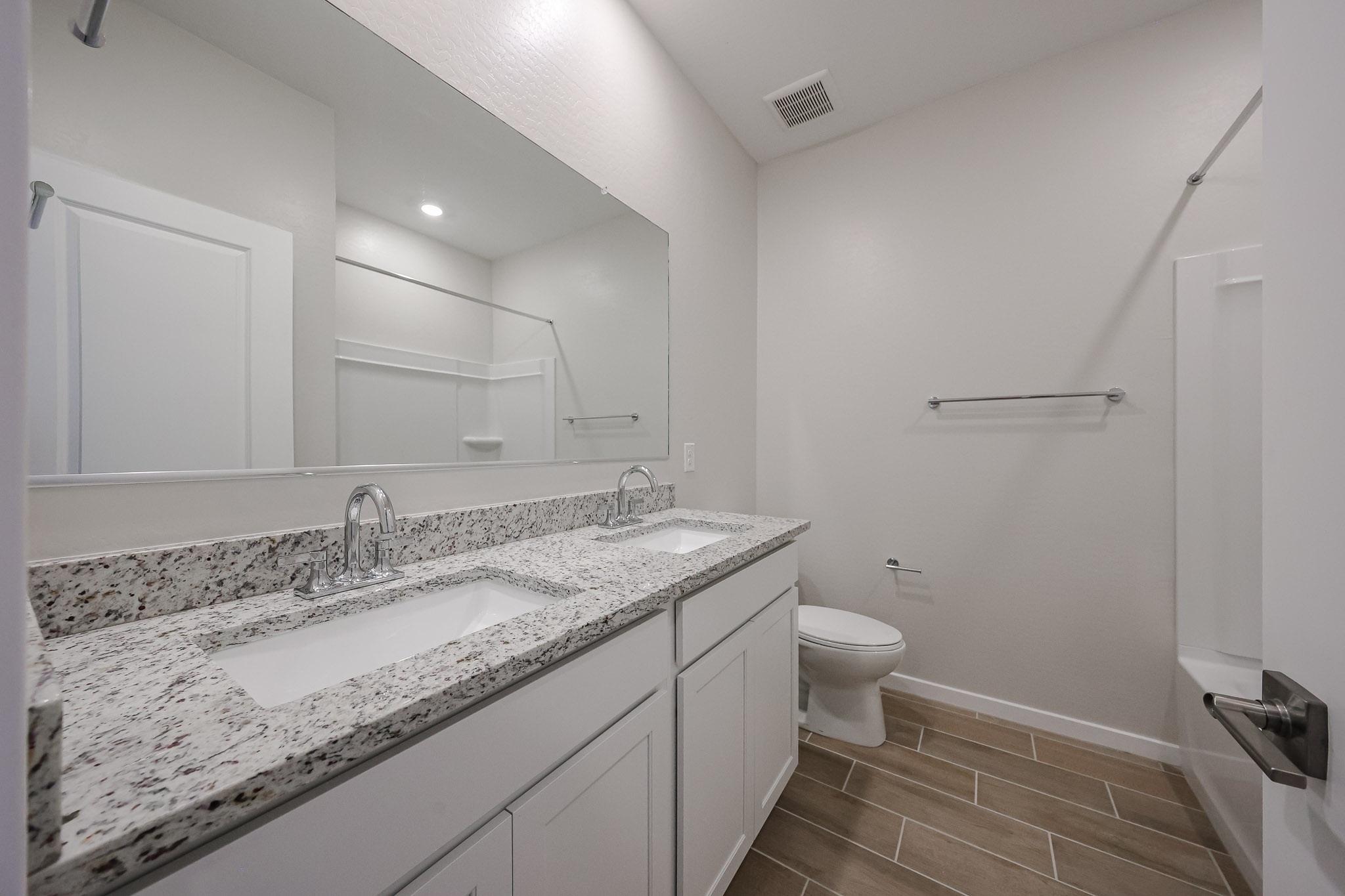 A bathroom with a large mirror.