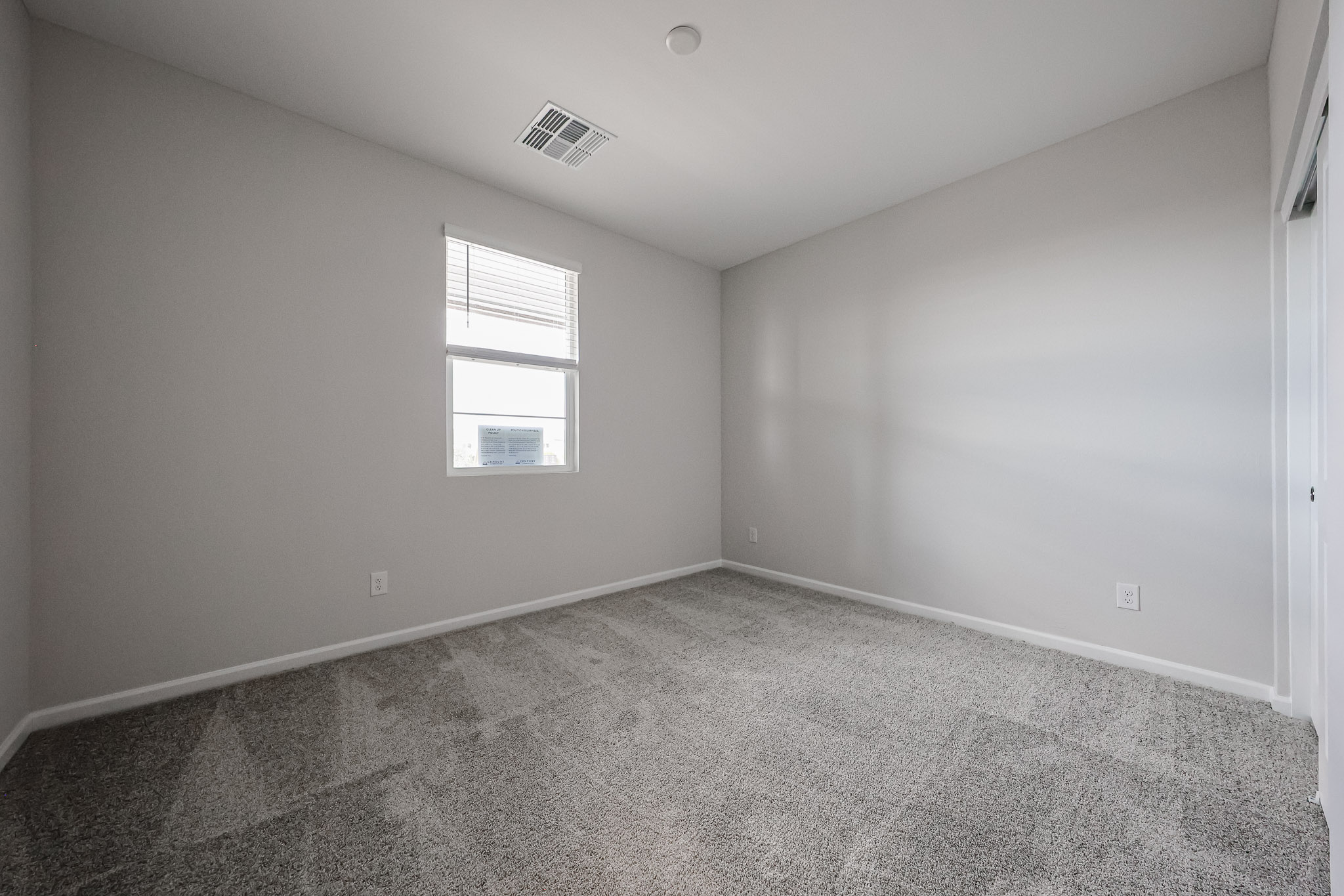 A room with a window and a carpet.