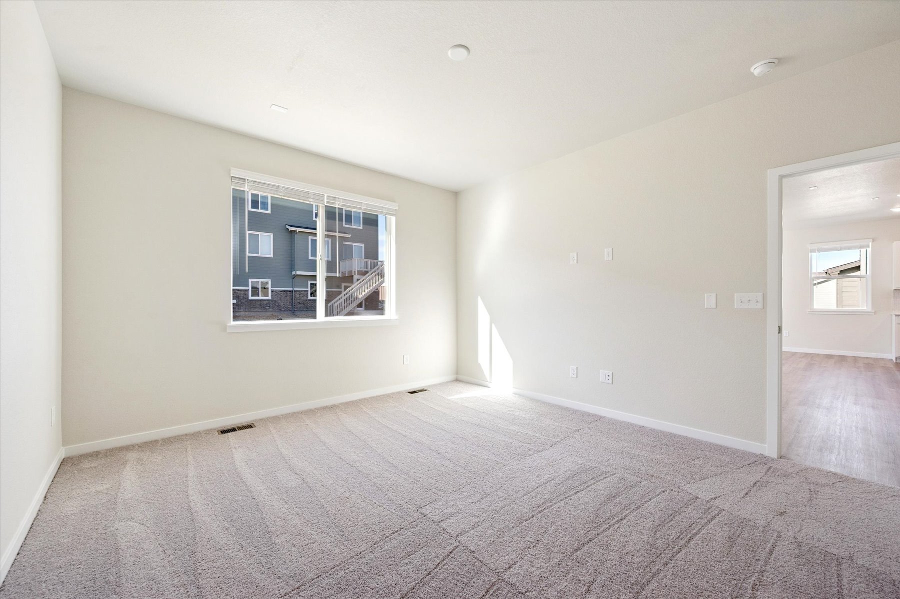 A room with a window and a carpet.