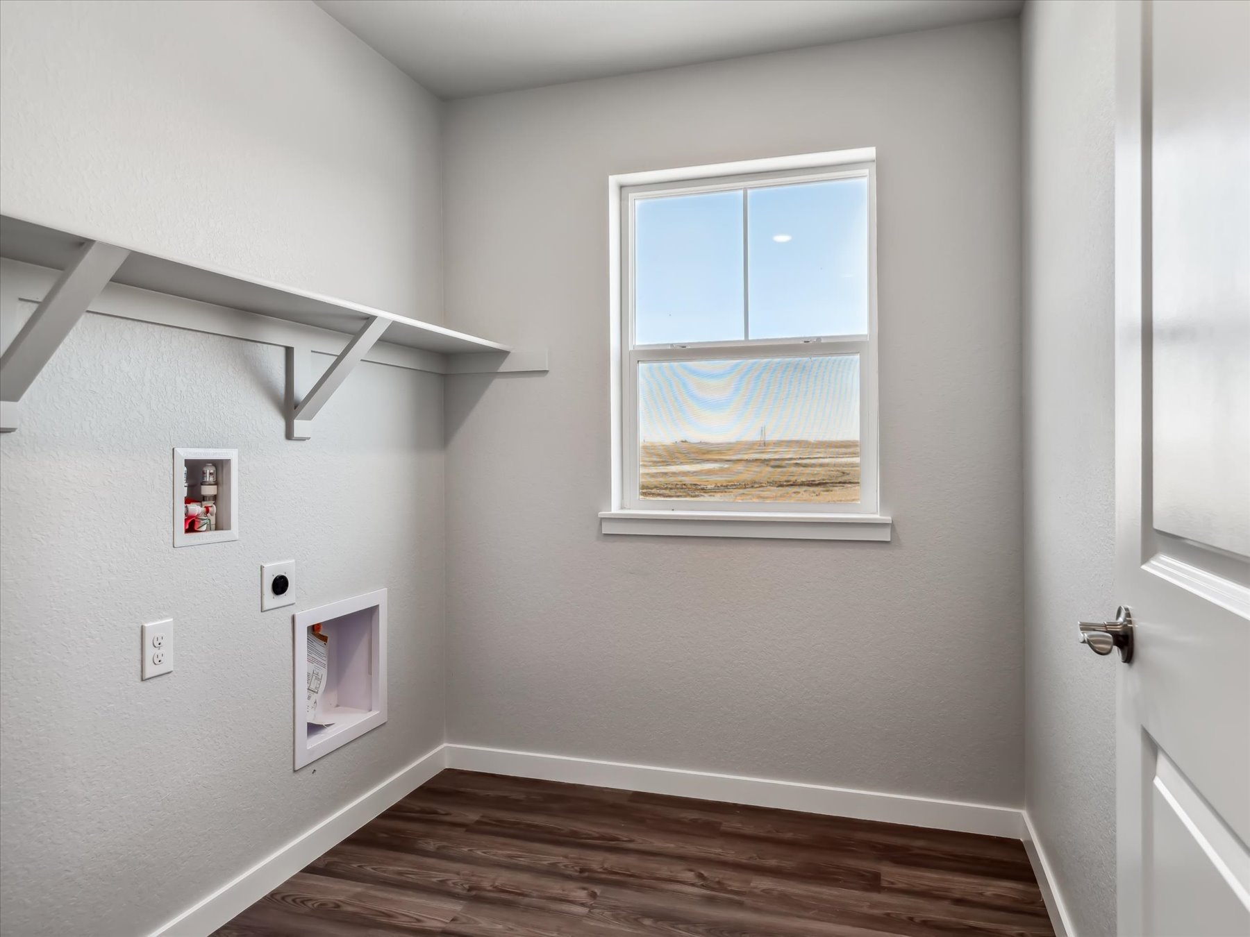 A room with a window and a wood floor.