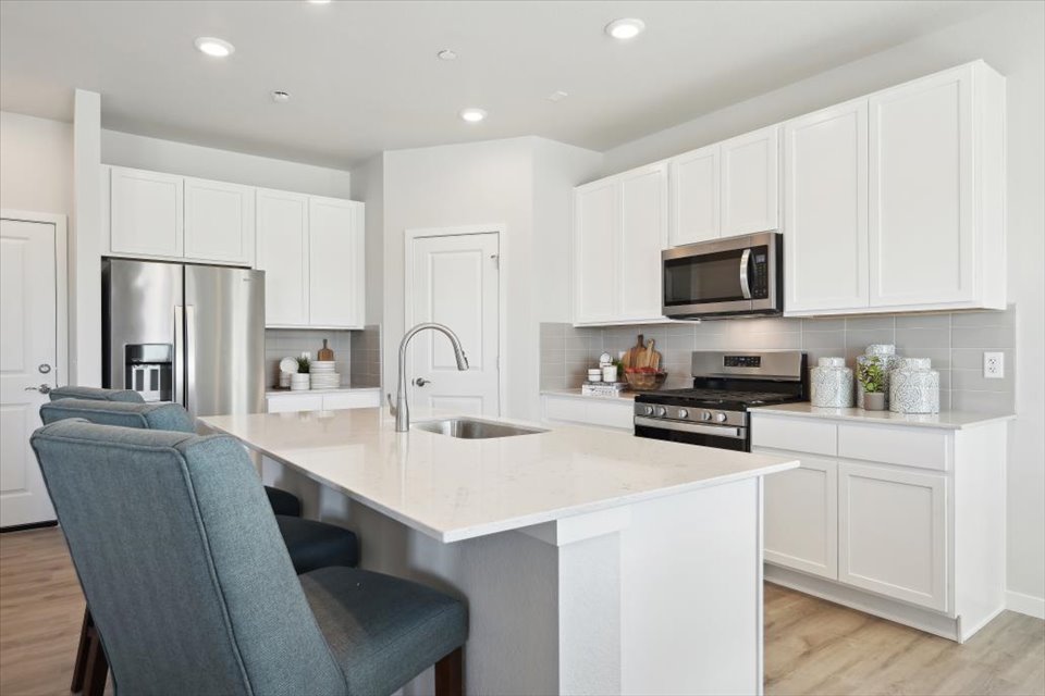 A kitchen with white cabinets.