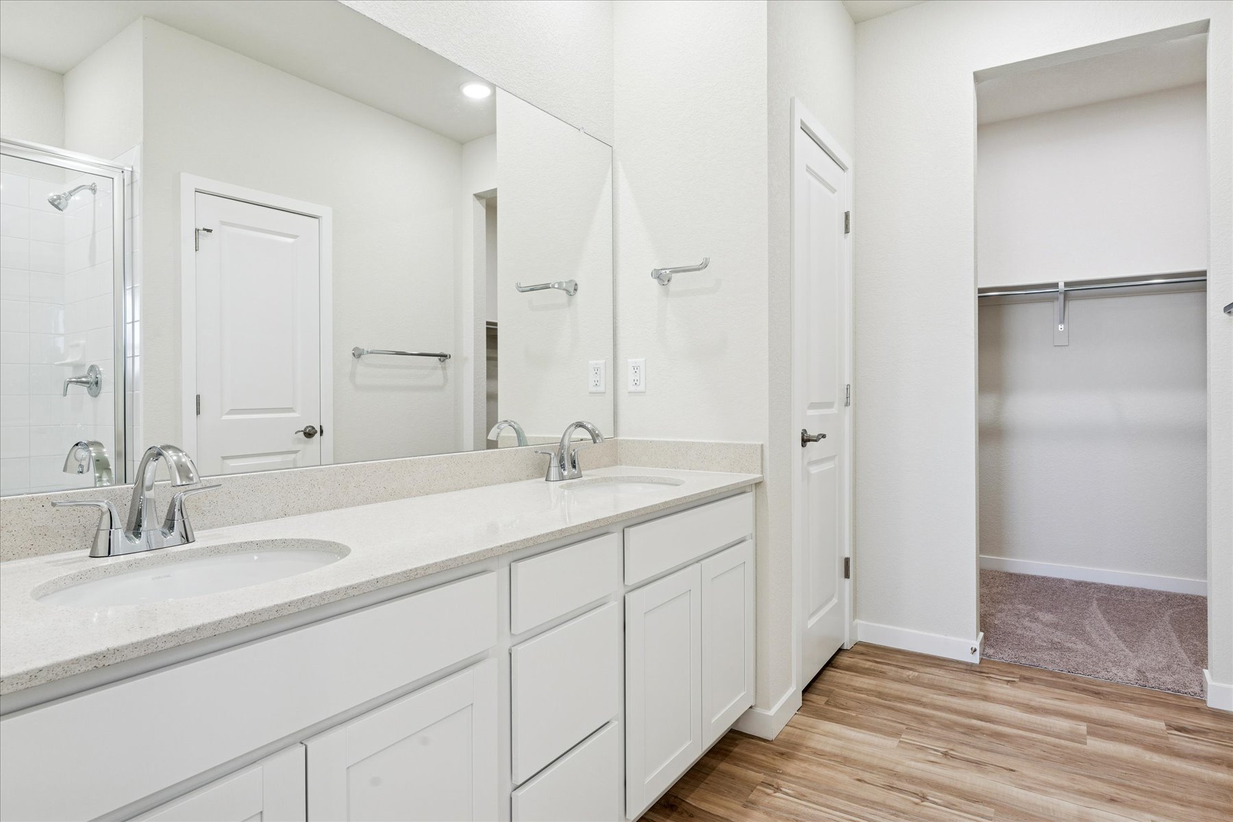 A bathroom with white cabinets.