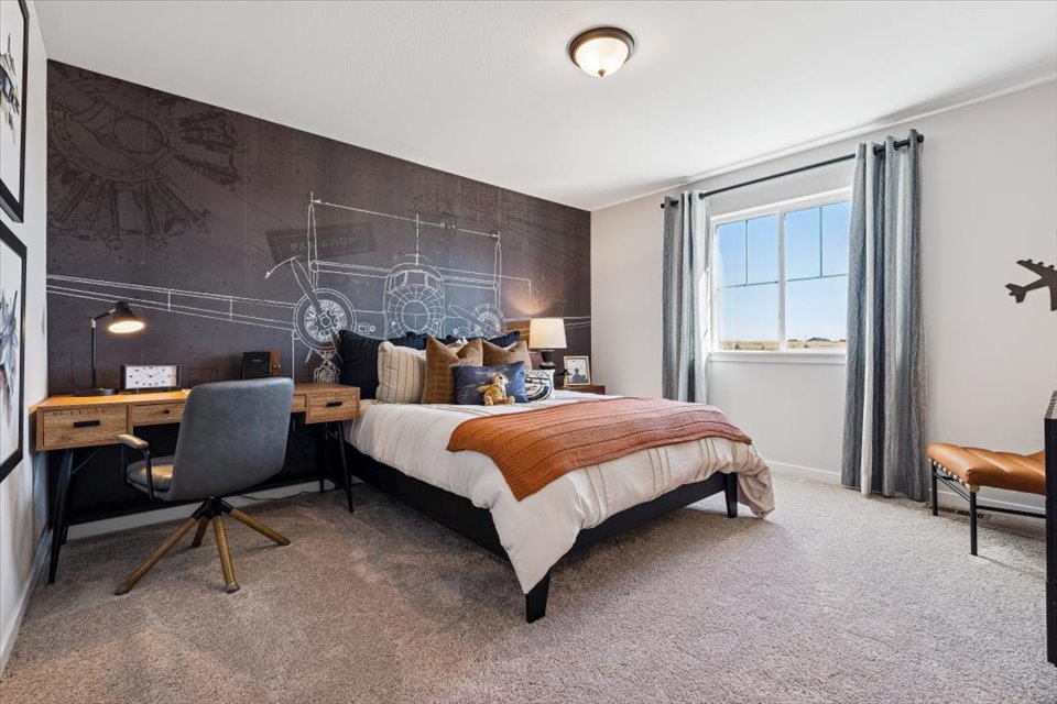 A bedroom with a bed desk and chair.