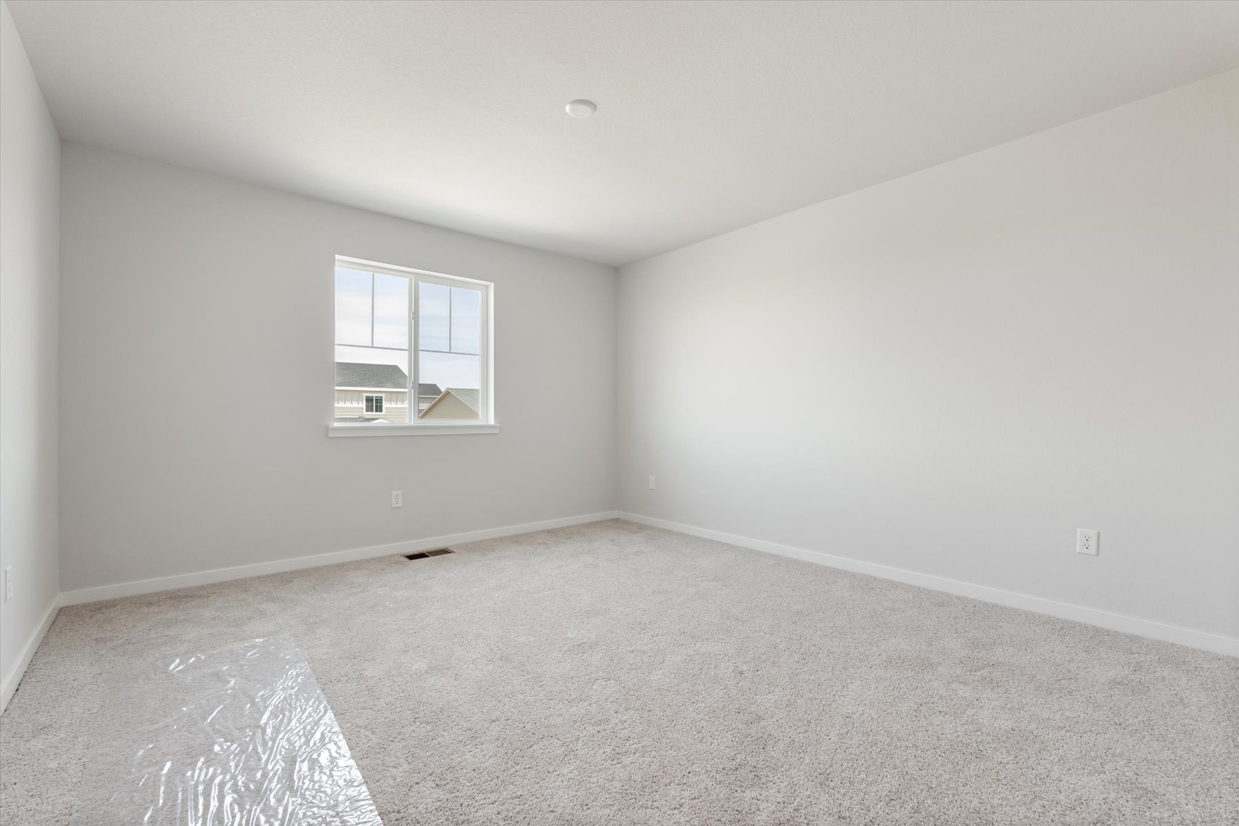 A room with a window and carpet.