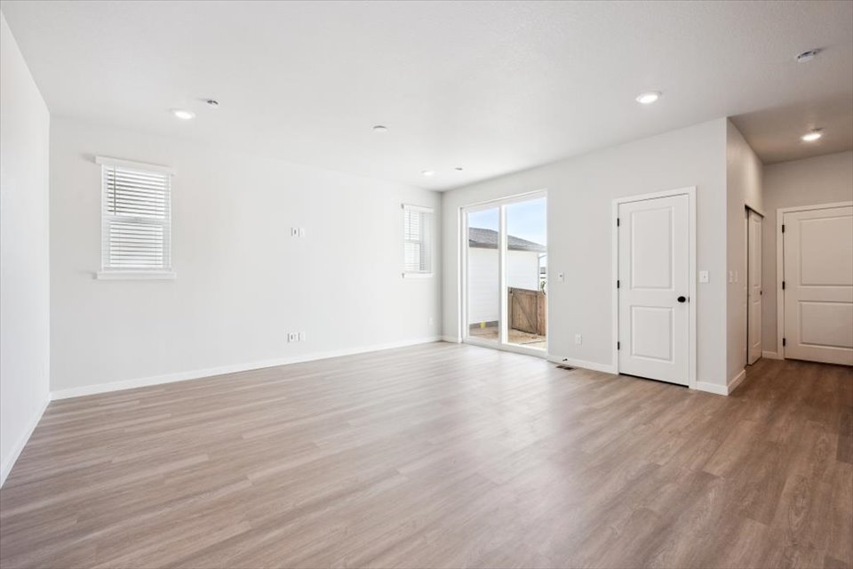 A room with white walls and wood floors.