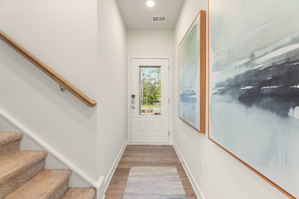 A hallway with a door and a painting on the wall.