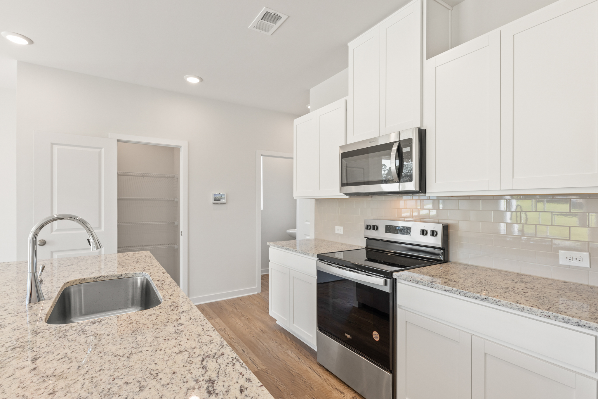 A kitchen with white cabinets.