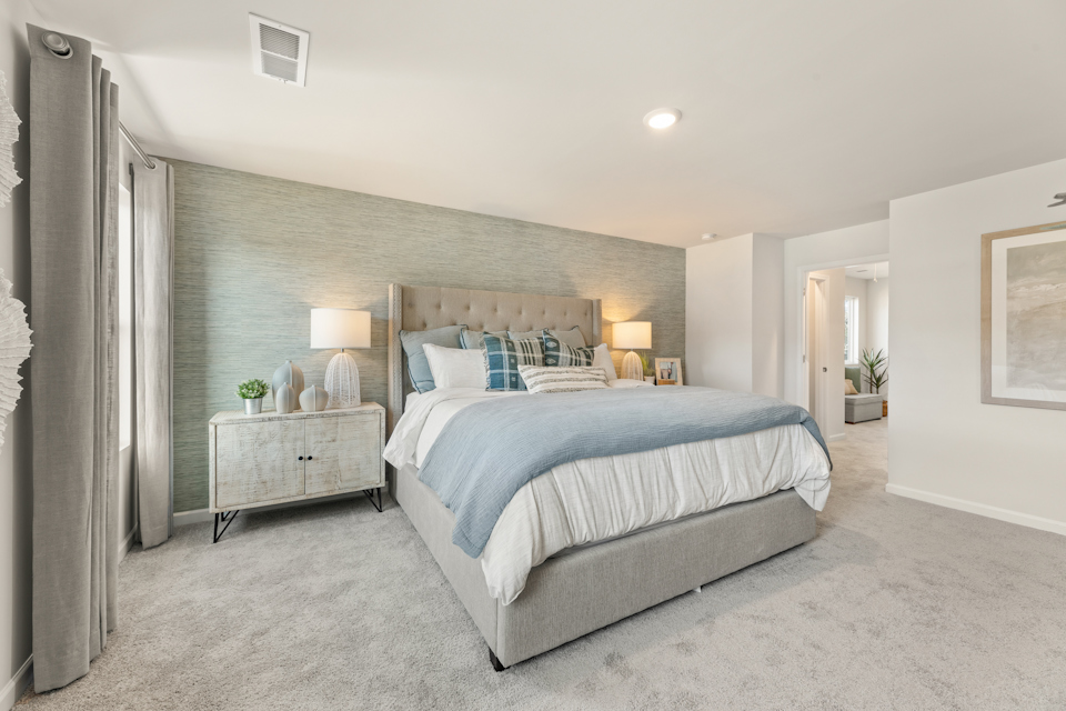 A bedroom with a bed and lamps.