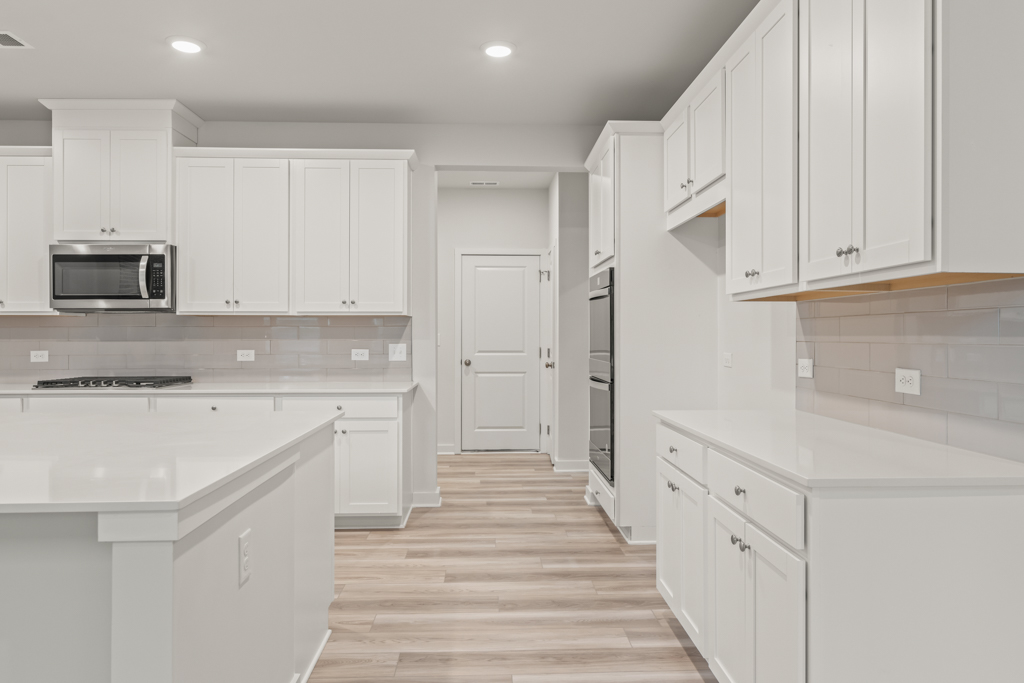 A kitchen with white cabinets.