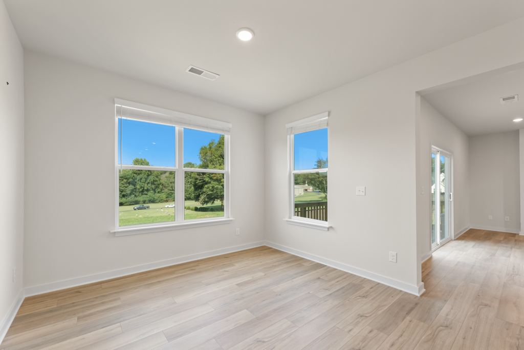 A room with windows and wood floors.