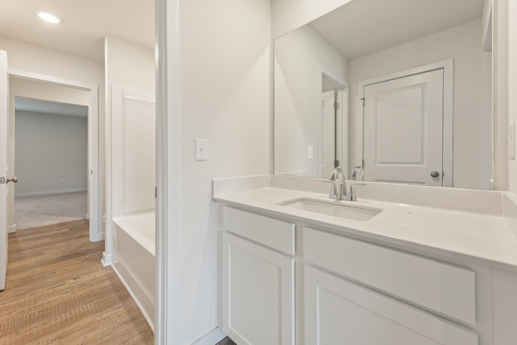 A bathroom with a tub sink and a shower.