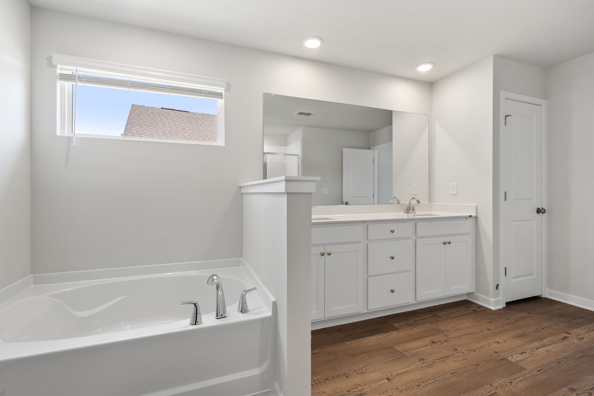 A bathroom with white cabinets.
