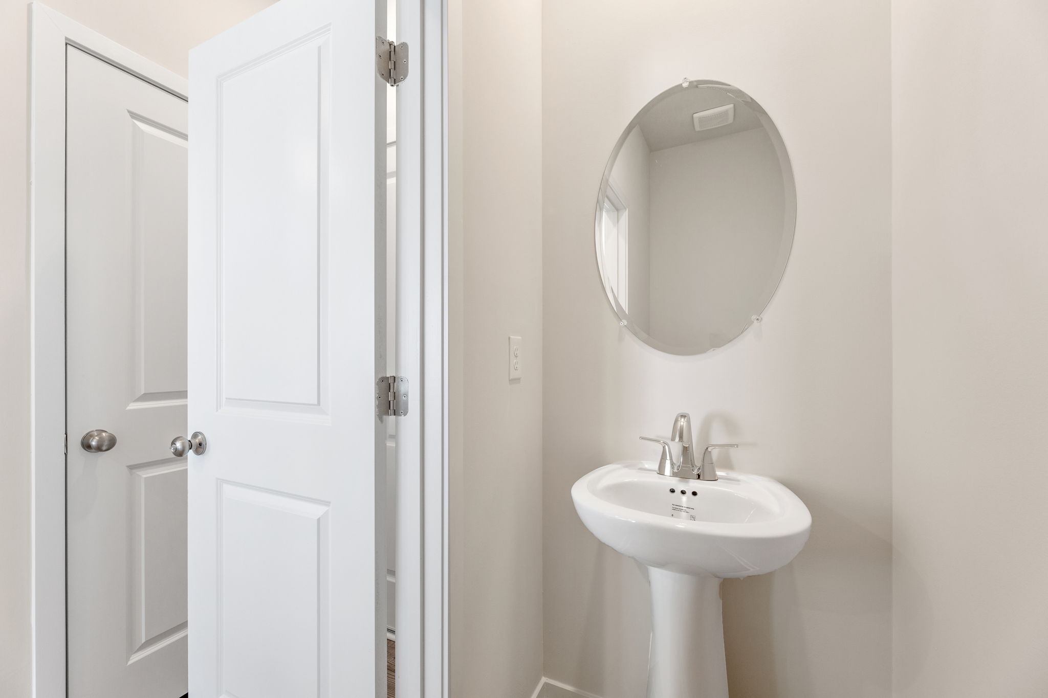 A bathroom with a round mirror.
