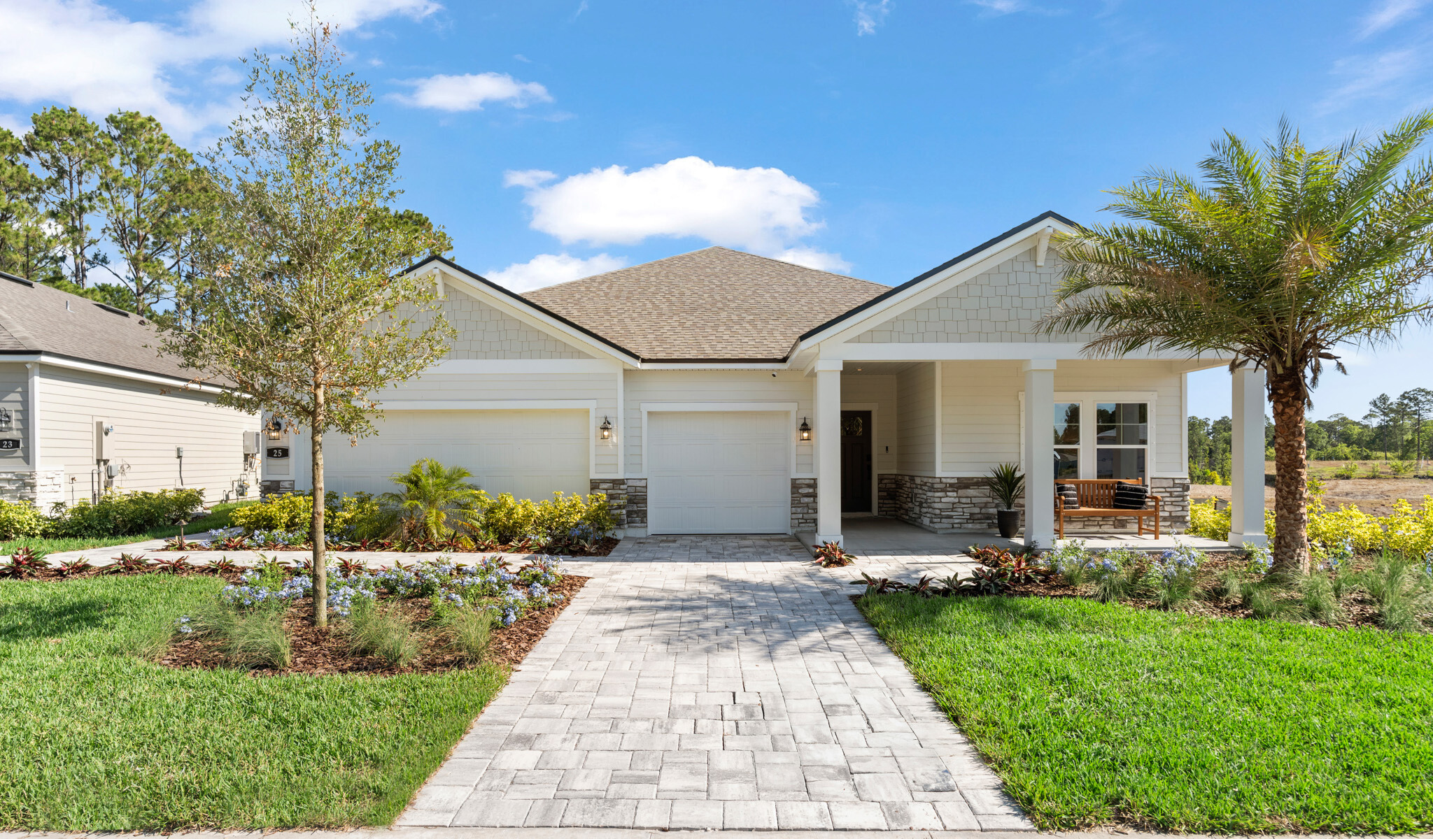 Kenai Model Home Exterior with 3 Bay Garage and Coastal Landscaping at Reserve East in Flagler Beach