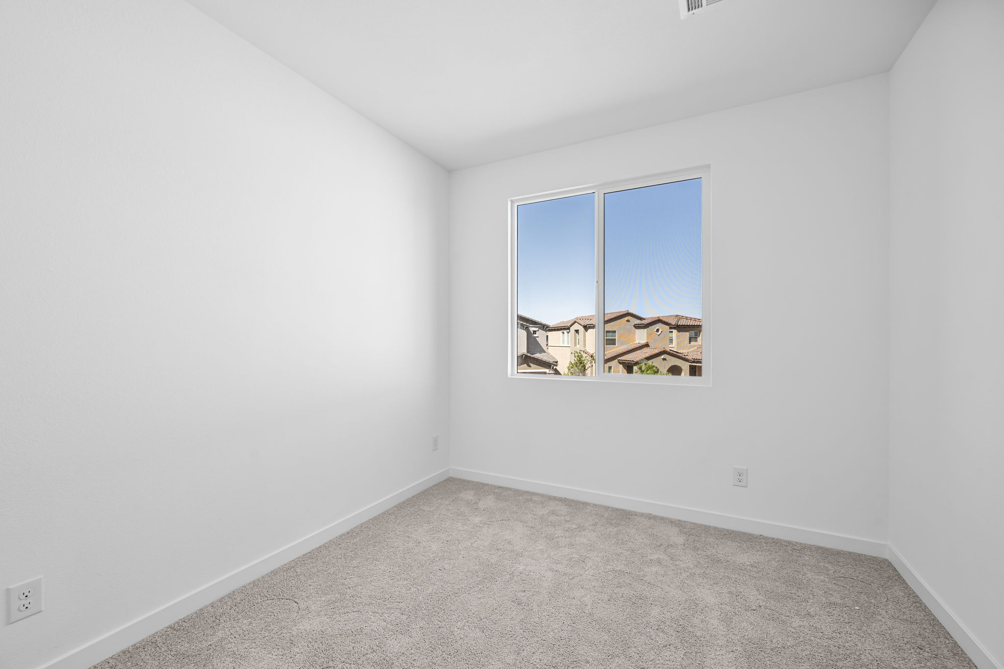A room with a window and a carpet.