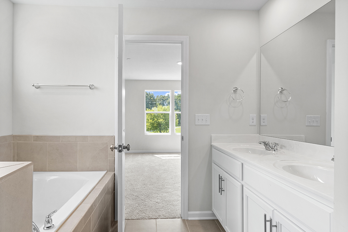 A bathroom with a tub sink and a shower unit.