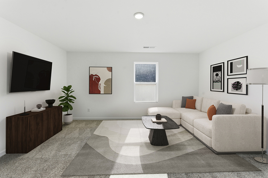 A living room with a large white couch and a tv.