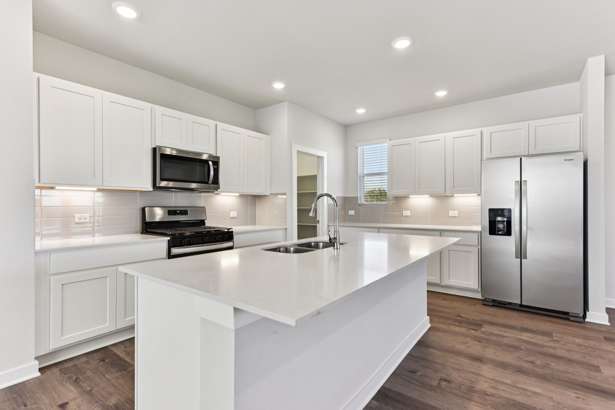 A kitchen with white cabinets.