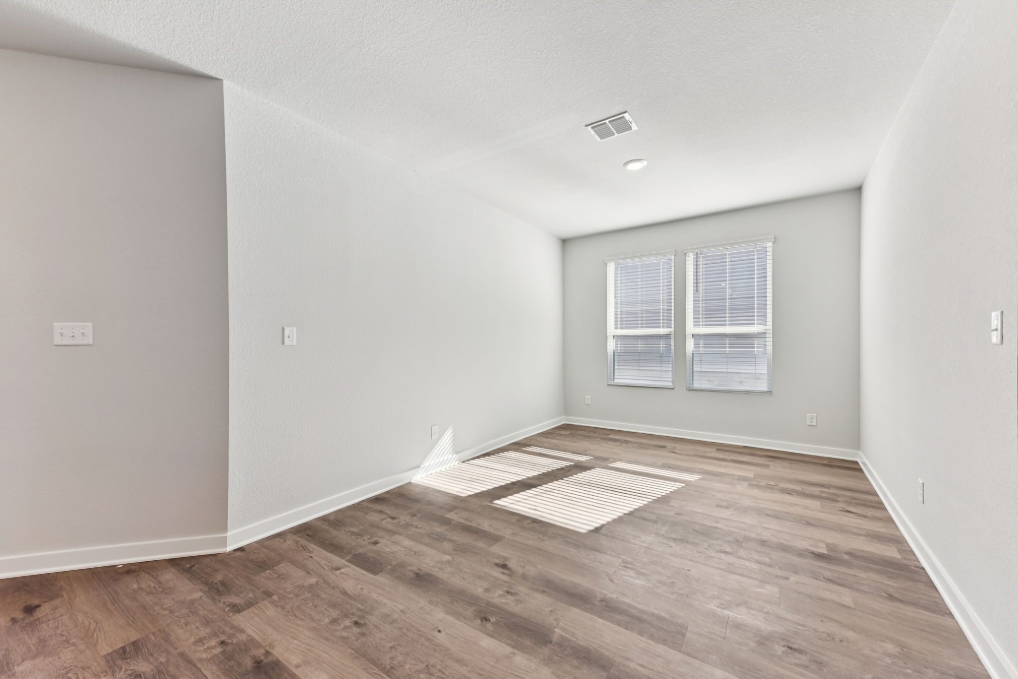 A room with a wood floor and a rug in it.