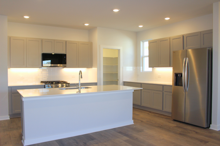 A kitchen with white cabinets.