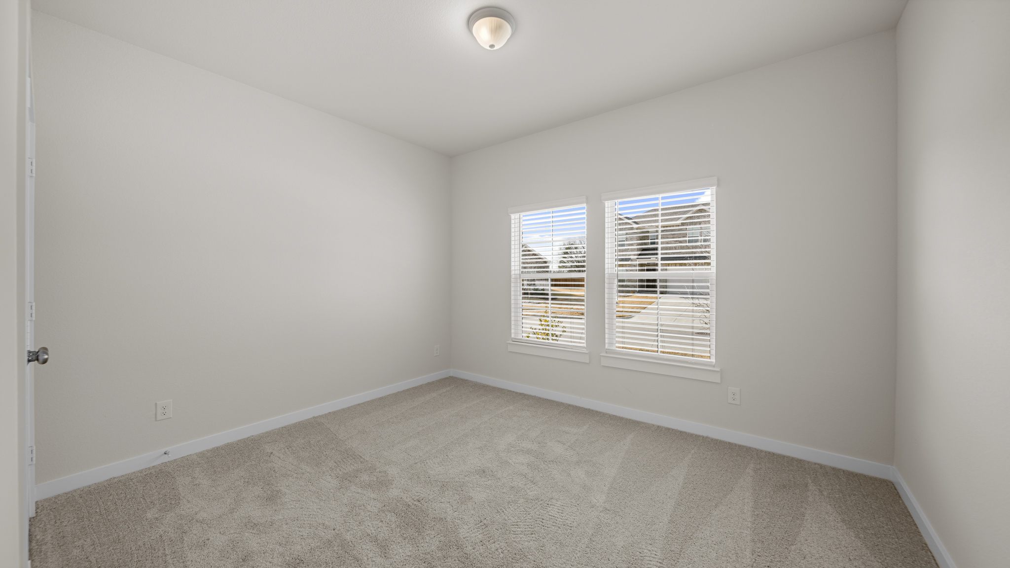 A room with a carpet and a window.