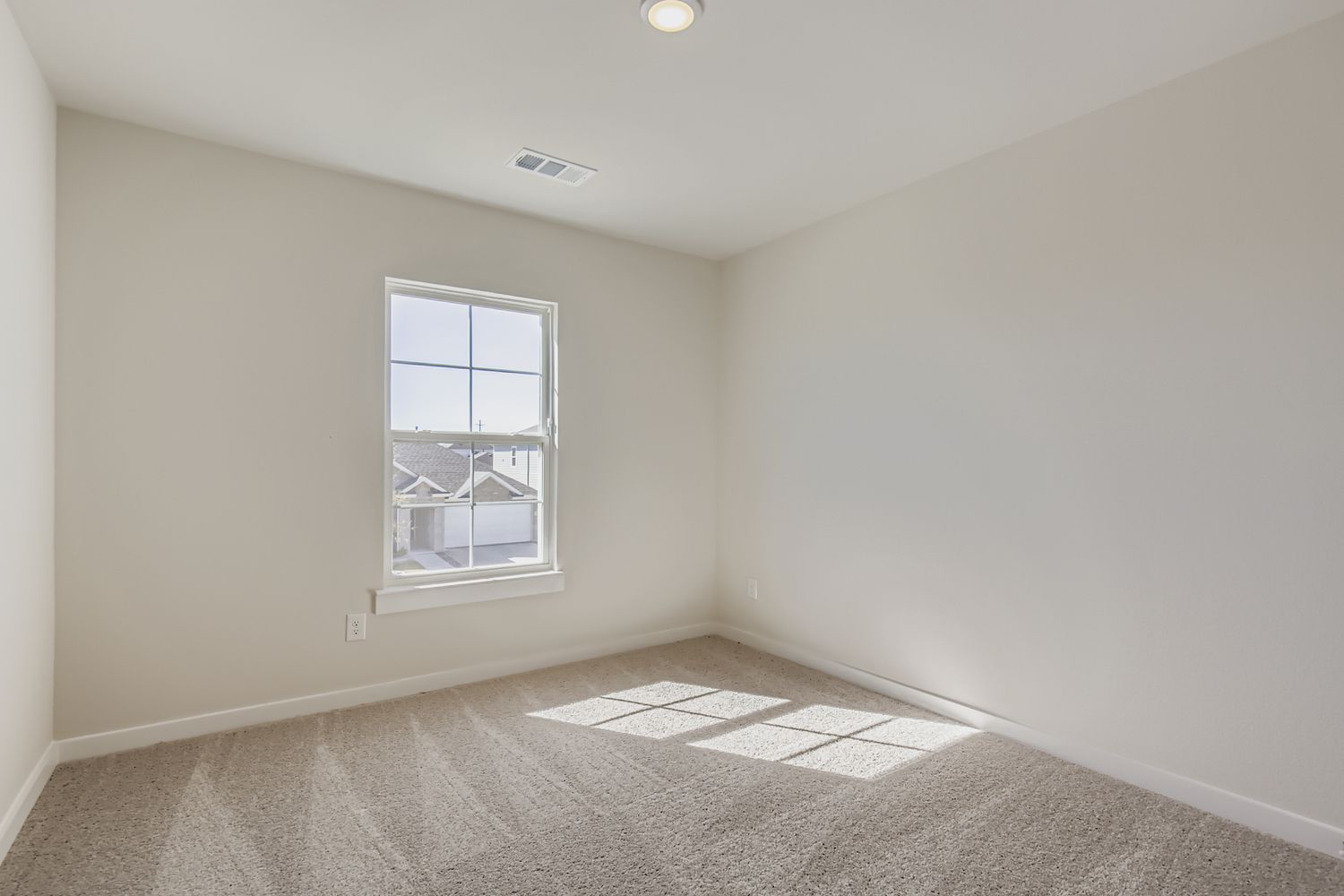 A room with a window and carpet.