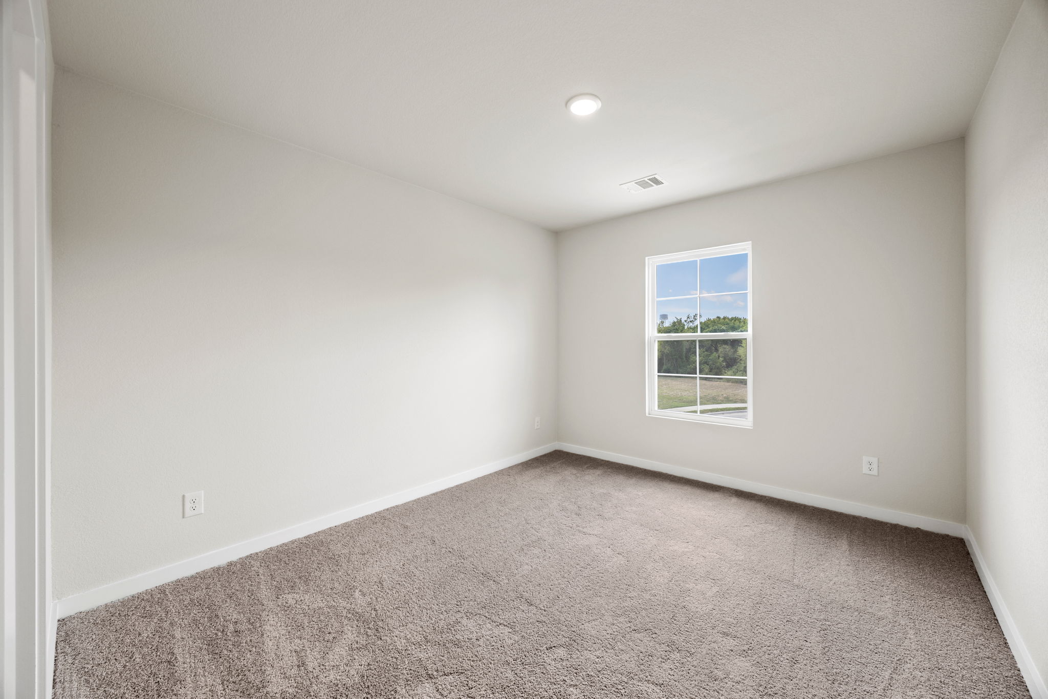 A room with a window and a carpet.