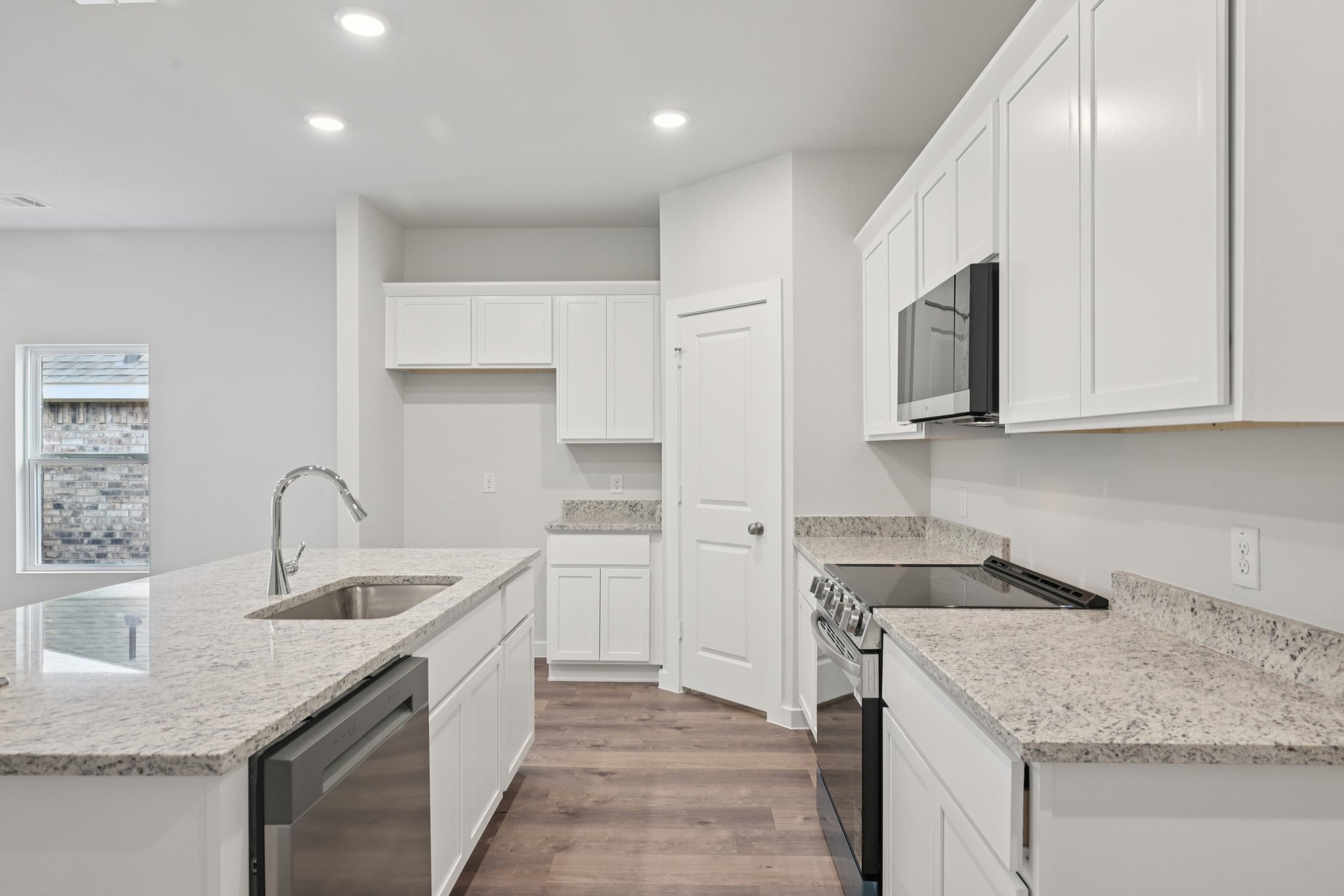 A kitchen with white cabinets.