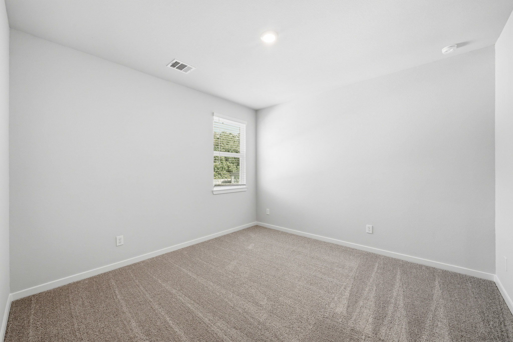 A room with a window and carpet.