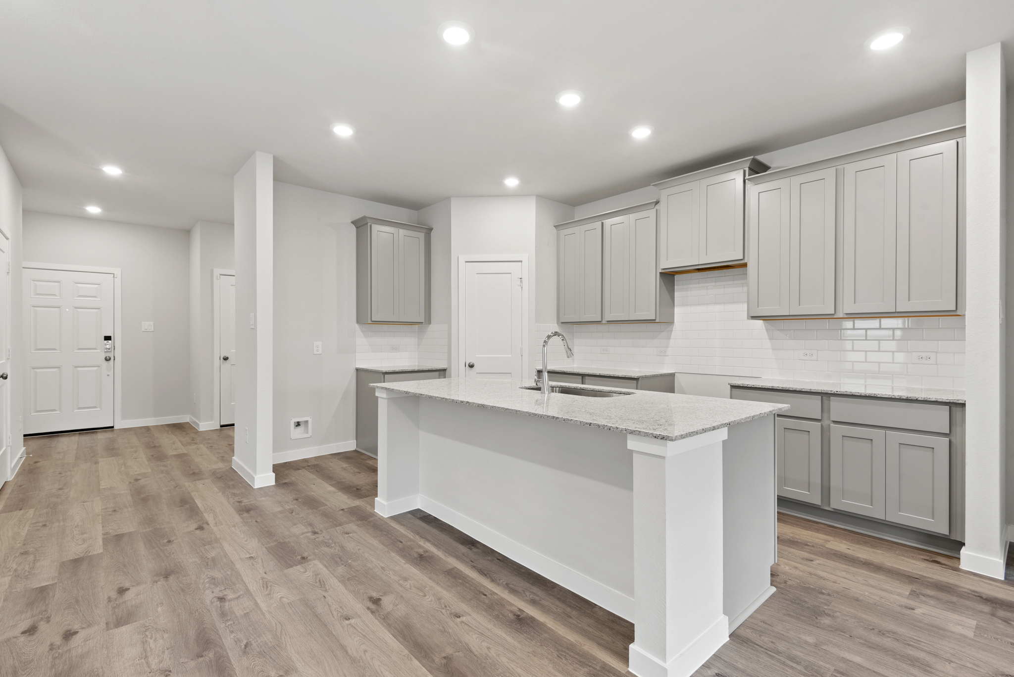 A kitchen with white cabinets.