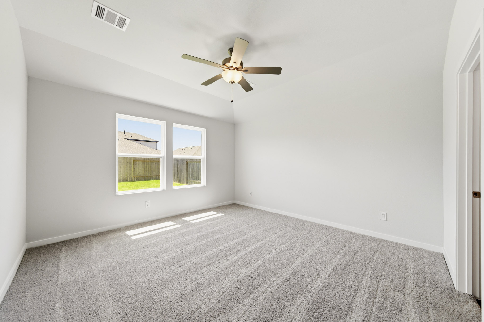 A room with a ceiling fan and a window.