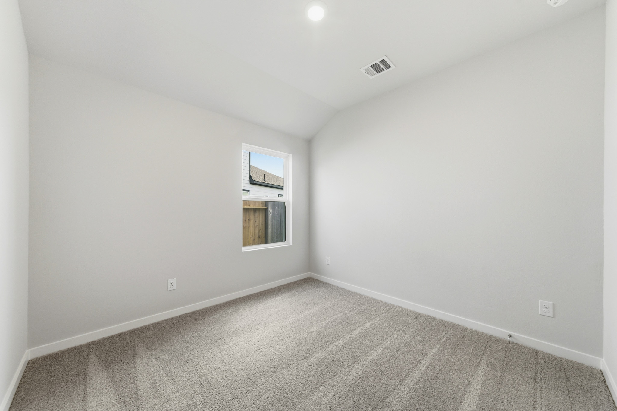A room with a carpet and a window.