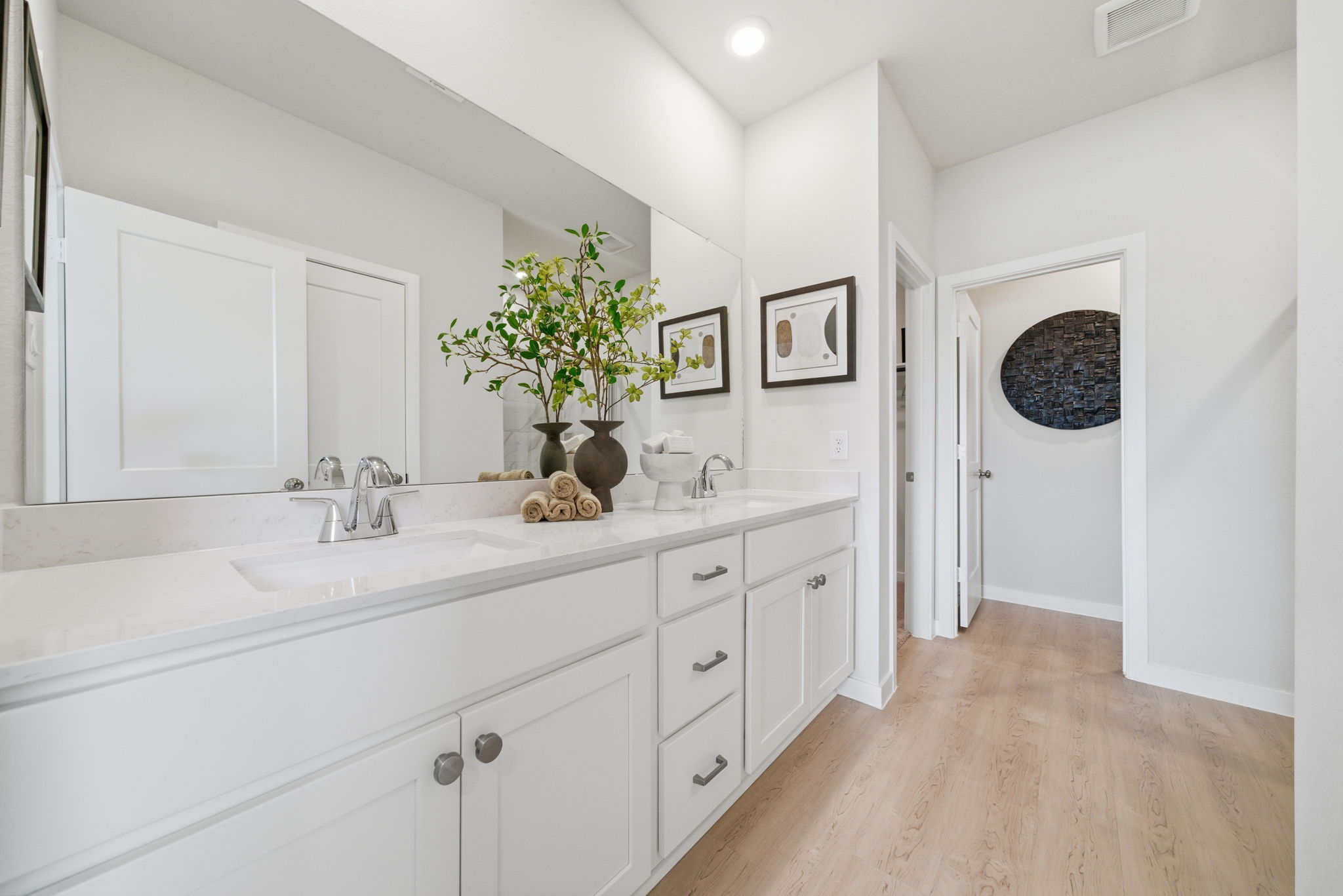 A bathroom with white cabinets.