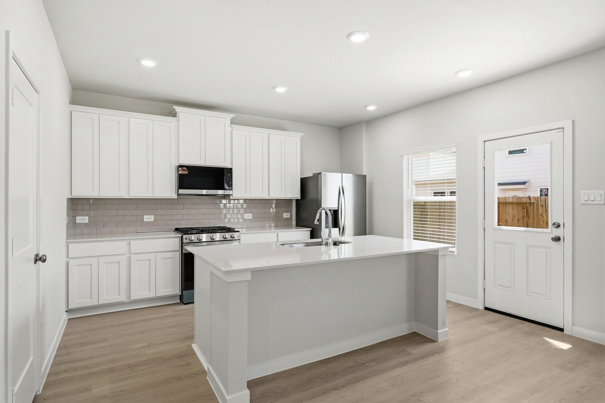 A kitchen with white cabinets.