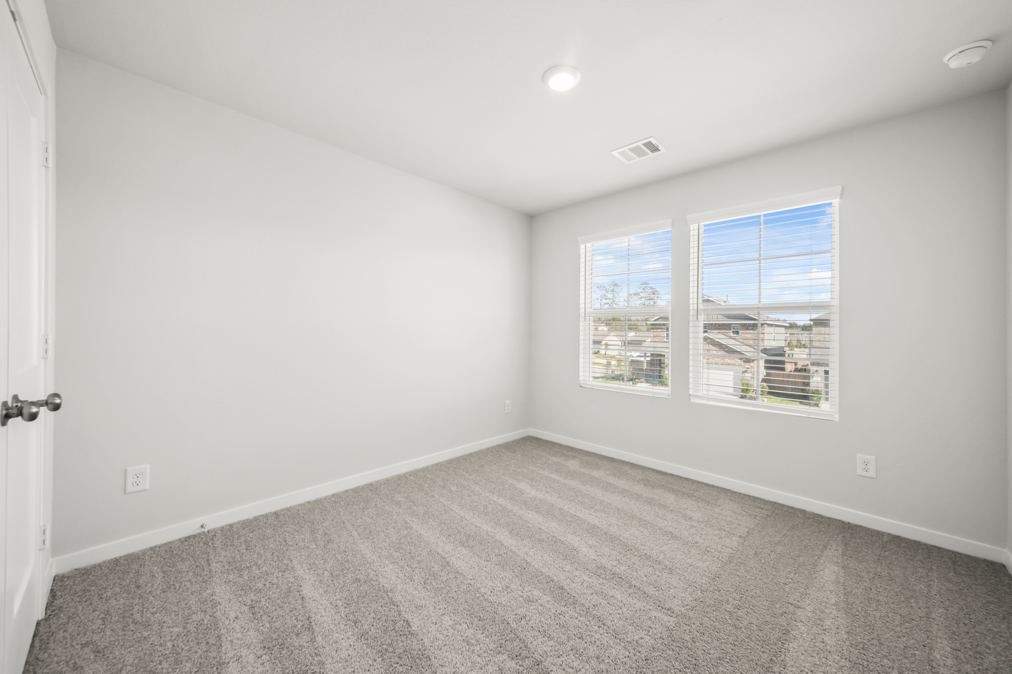 A room with a window and a carpet.