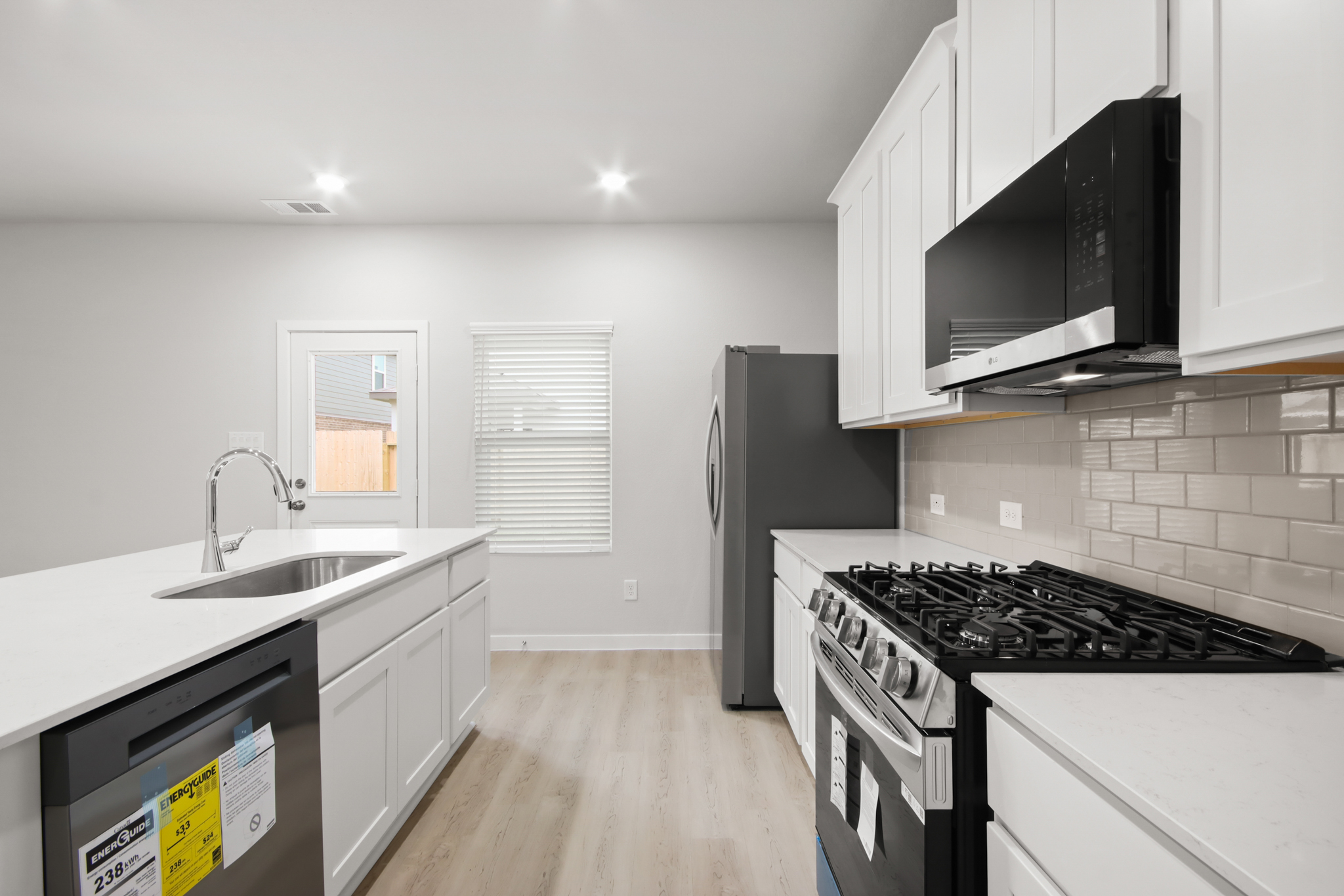 A kitchen with white cabinets.