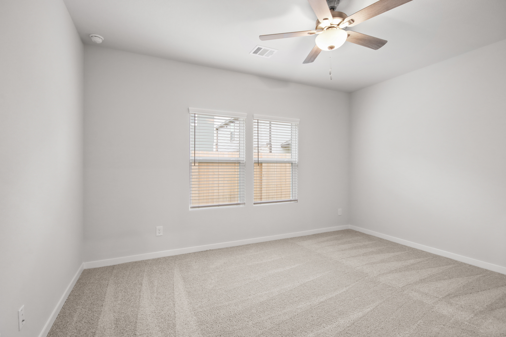 A room with a ceiling fan and a window.