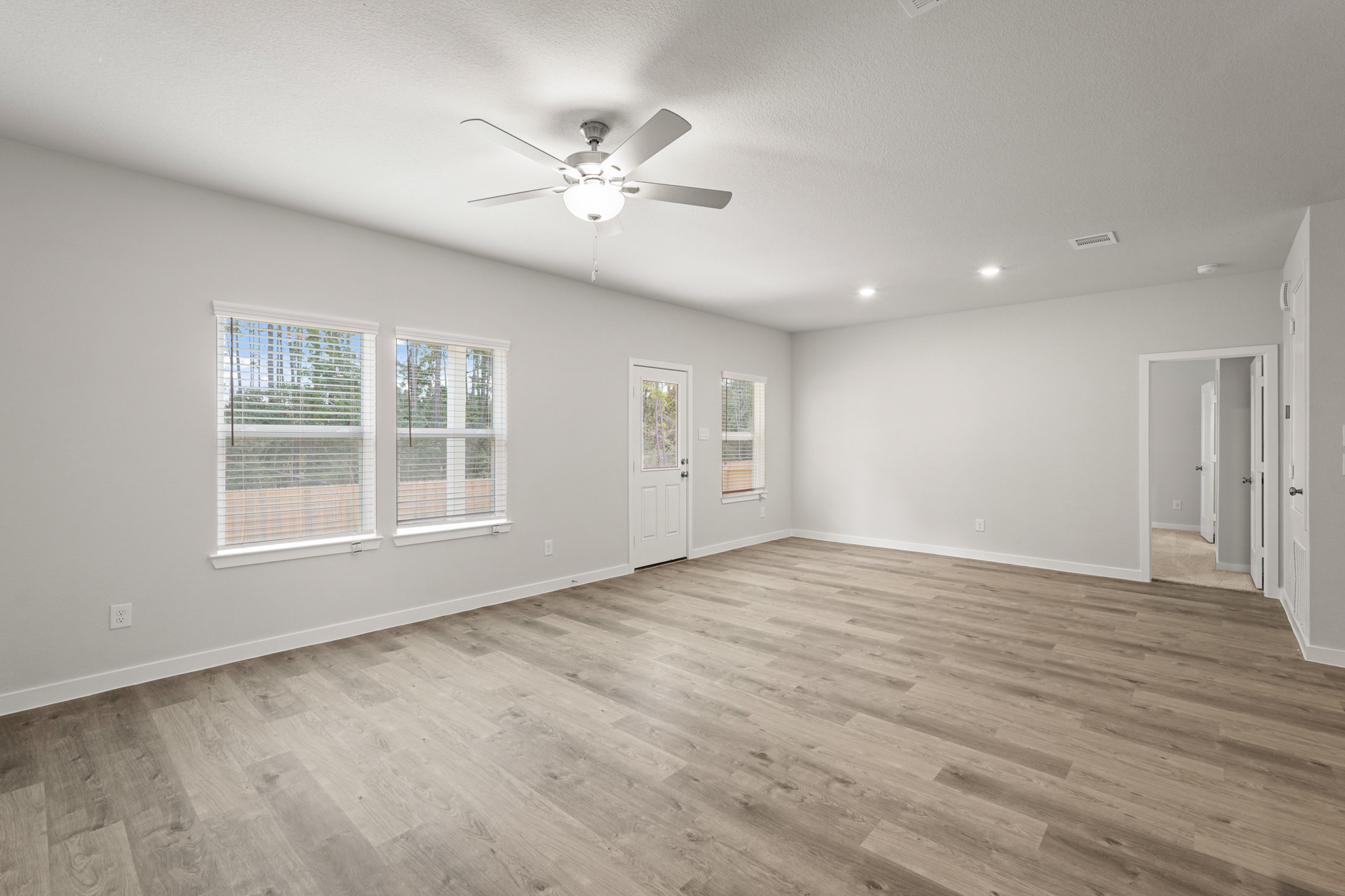 A room with a wood floor and a ceiling fan.