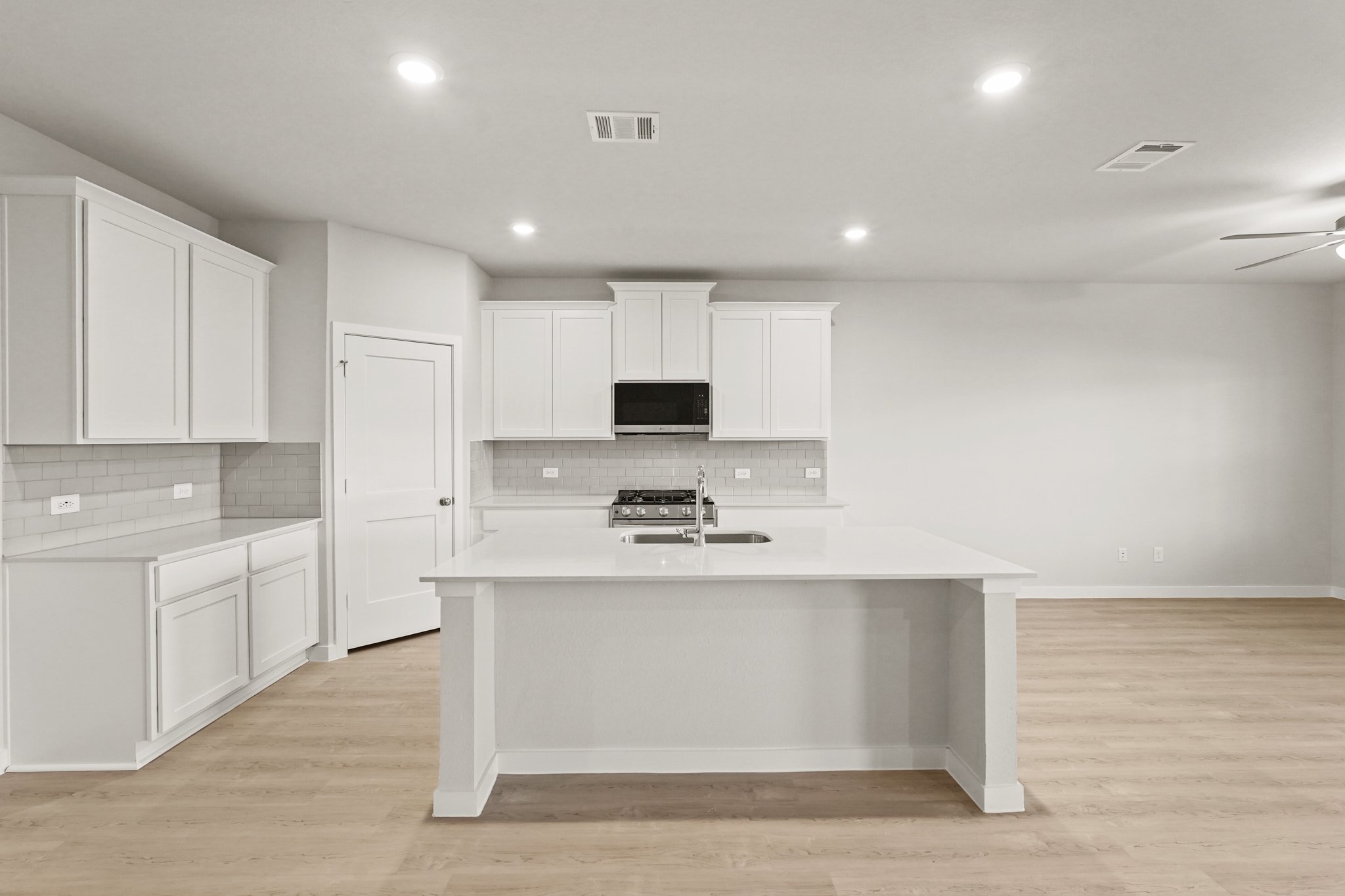 A kitchen with white cabinets.
